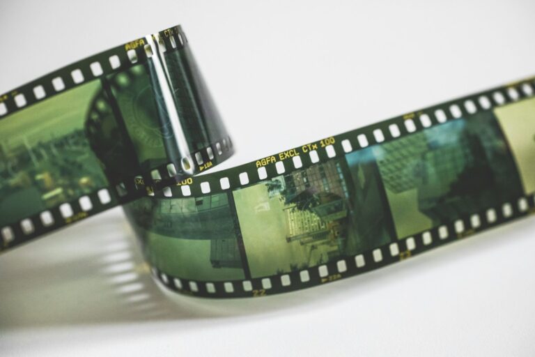 Vintage 35mm movie camera and physical film editing strips representing French New Wave cinema