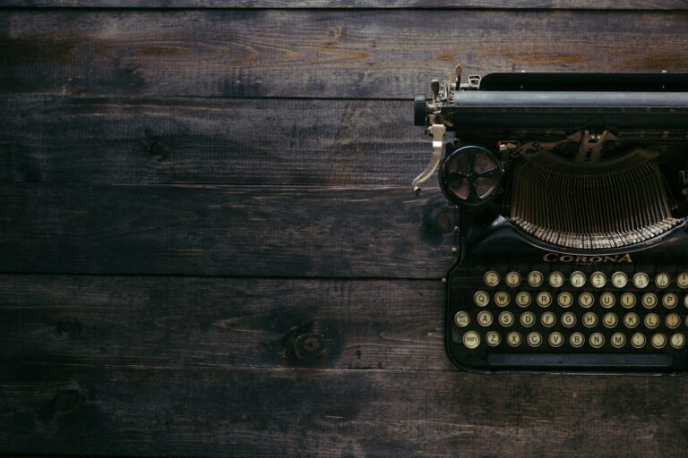 Vintage manual typewriter mechanical round glass keys and carriage on a wooden writing desk