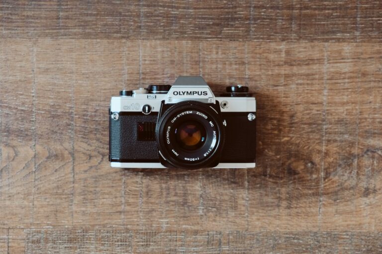Rangefinder Cameras Versus Single Lens Reflex Systems: Mechanical Evolution of Street Photography Tools Classic 35mm rangefinder camera on table with brass lens and mechanical shutter